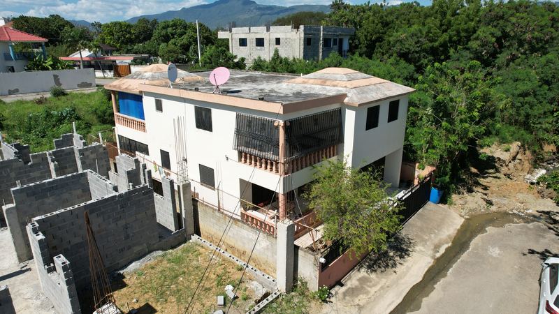 Vivienda heredada de dos niveles junto a una construcción vecina sin terminar